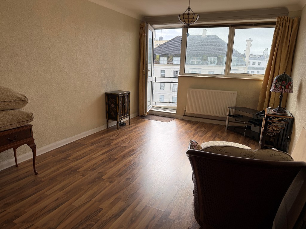 Lot: 22 - BALCONY FLAT WITH SEA VIEWS IN NEED OF UPDATING - Living room with access to balcony